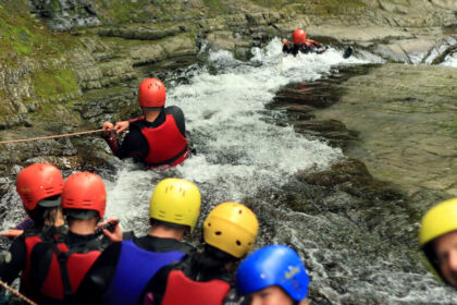 Descending the huge slide on the Canyoning adventure